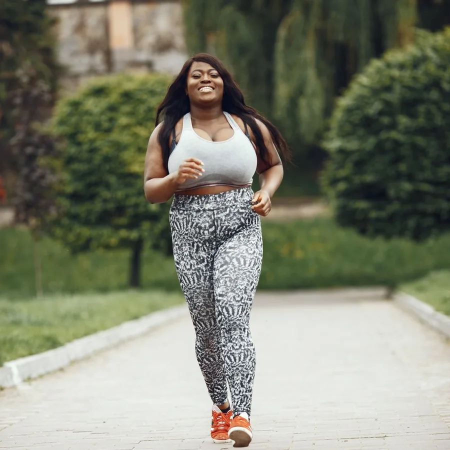 Smiling woman running outdoors in athletic wear